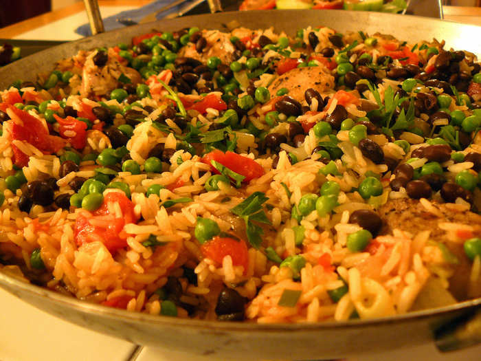 Sit down to a hearty and flavorful meal of arroz con pollo, rice mixed with chicken, vegetables, and black beans, in Havana, Cuba.