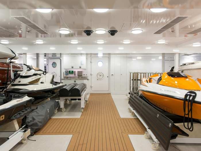 The belly of the yacht holds luxury water sports toys including multiple jet skis and an additional smaller boat for waterskiing.