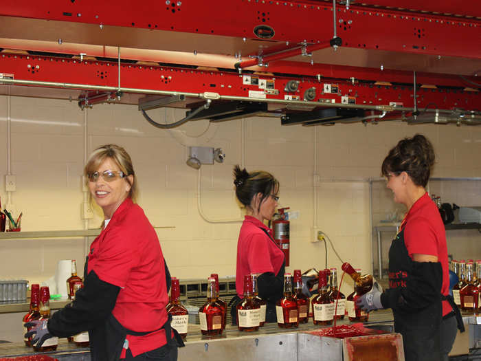 But the signature red wax seal is dipped by hand. Four women dip the tops into steaming vats of melted red wax, 72,000 a day.