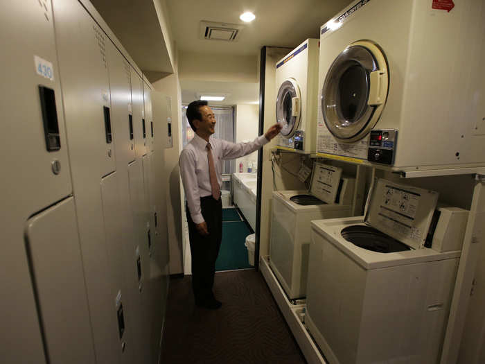 A capsule hotel in Tokyo offers coin-operated washing machines for guests.