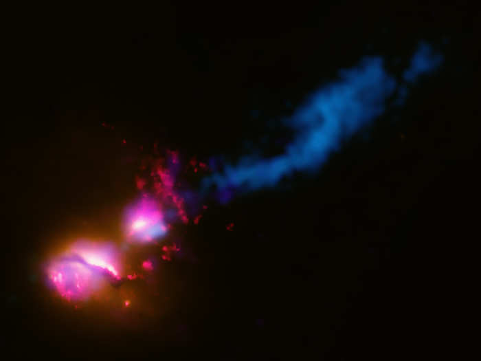 The jet from a black hole at the center of a galaxy strikes the edge of another galaxy in this composite image.