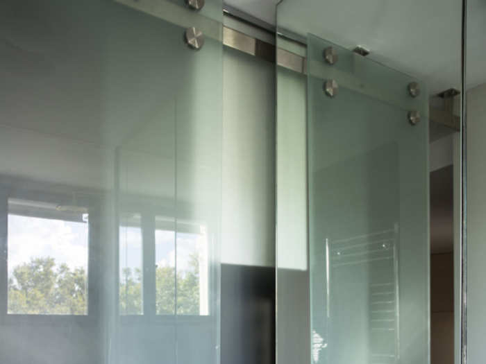 The bathroom has storage space above the sink behind the mirror.