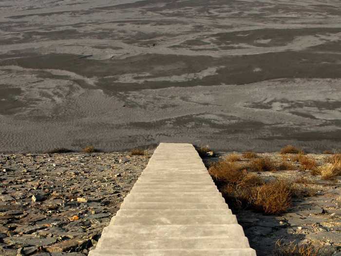 Stairs lead into a tailings dam with polluted water.