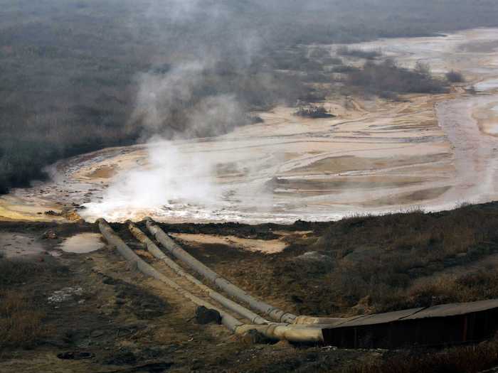 Often the sludge is just dumped in open mounds. Here we see pipes from a rare earth smelting plant dump polluted water near Xinguang Village.