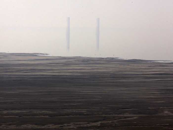 The air is so polluted the chimneys from a smelting plant are barely visible.