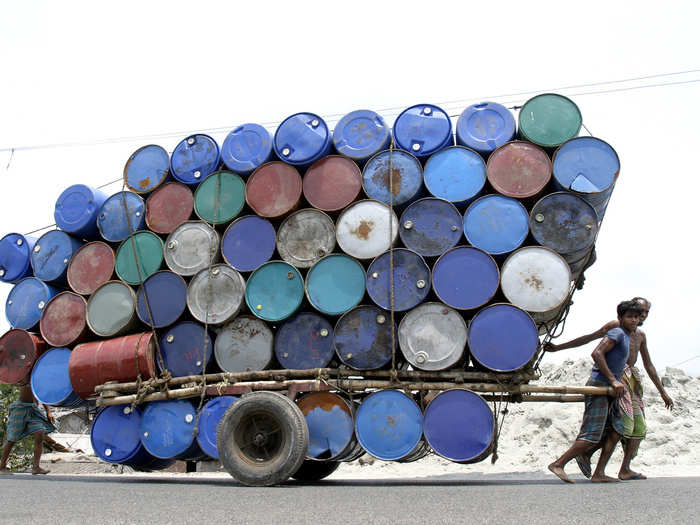 Two people pull a cart of used containers in Dhaka, Bangladesh.