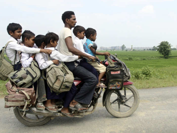 A man and six children share one motorcycle in India