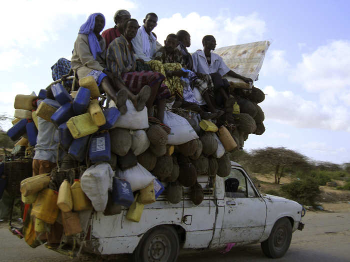 This truck in Mogadishu, Somalia is overloaded with people and supplies, including milk.