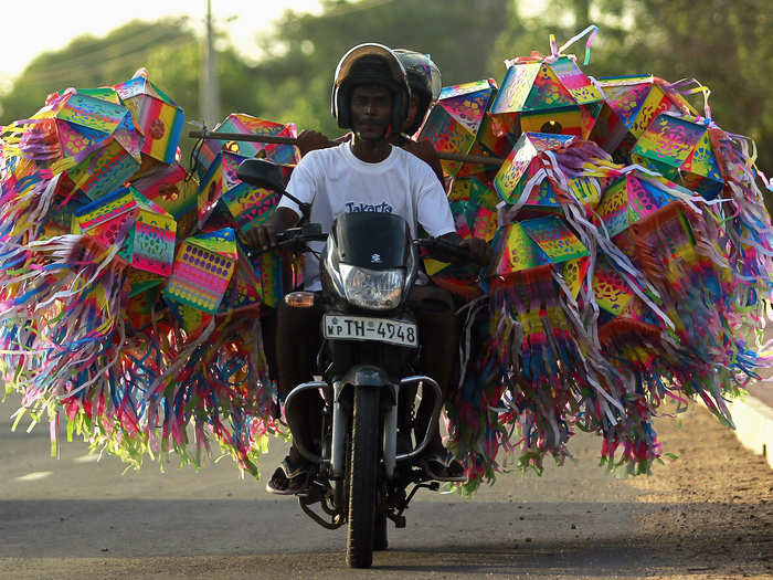 Two men transport lanterns on a motorbike in Colombo, Sri Lanka.