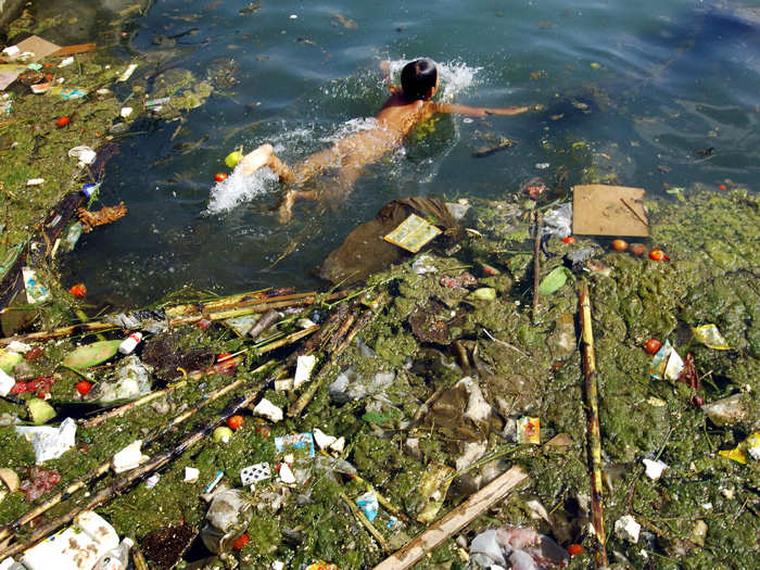 A child swims in a polluted reservoir, southwest of China