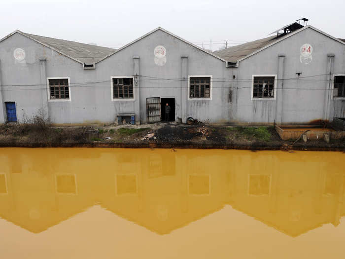 A manufacturer of screws and nuts is situated next to a polluted river in Jiaxing, Zhejiang province.