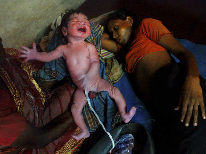 A new life is born. The midwife holds up the boy as Sajila lays beside. Her economic condition was even worse during her pregnancy and she had to starve for several days. She gave birth to her child without any modern facilities or medicines, and in an unhealthy atmosphere. It might sound incredible to many, but Sajila walked home with her son only an hour after giving birth.