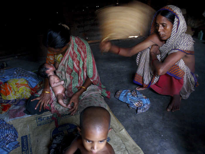 Sajila breast-feeds the baby boy in her unsanitary and suffocating room.