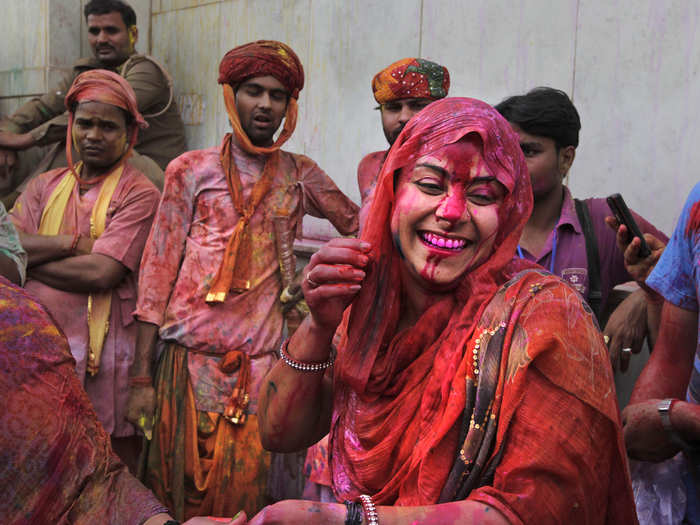Smeared with color, people dance and play at the Nandagram temple in Nandgaon, about 75 miles from New Delhi.