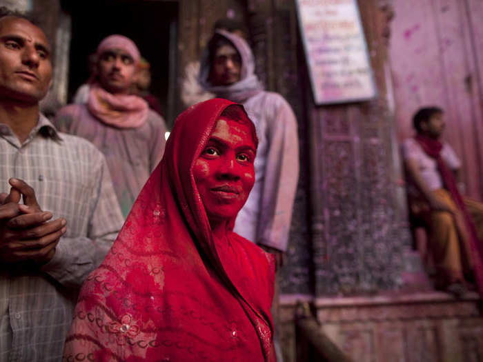 A Hindu devotee is covered in red powder at the Banke Bihari temple in Vrindavan, India.