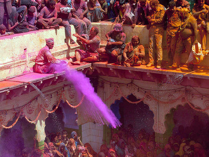 Hindu devotees play with colored powders at the Bankey Bihari Temple in Vrindavan, India.