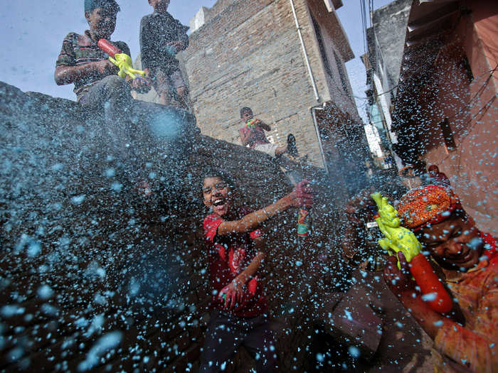 Boys spray colored foam near the Bankey Bihari temple in Vrindavan.