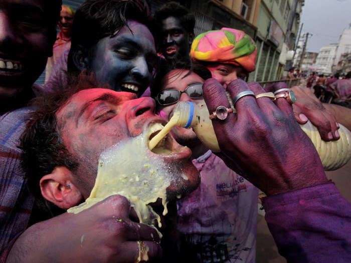 A man chugs bhang, a drink made of milk and cannabis, during Holi.