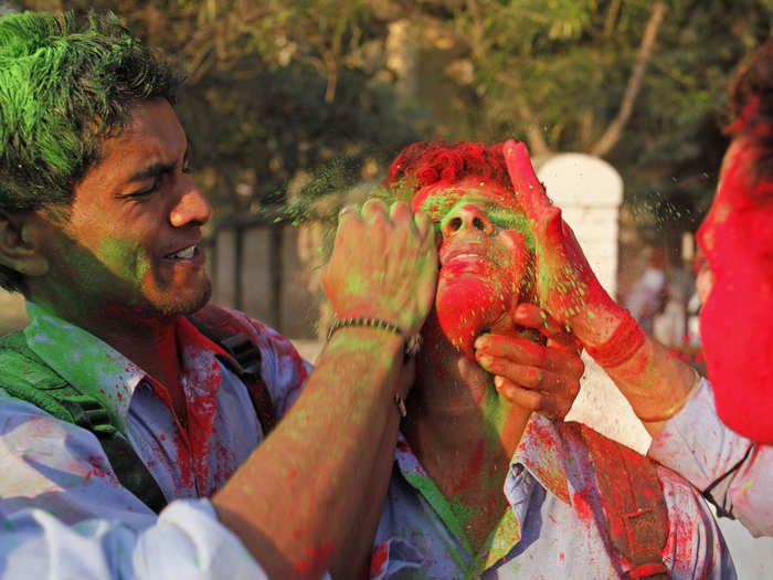 Students from Allahabad University smear colored powder on each other to celebrate Holi in Allahabad, India.