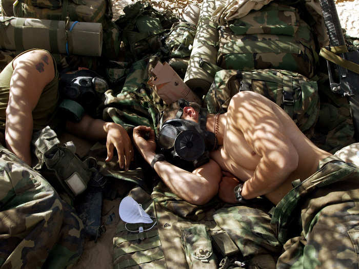 U.S. Marines of the 15th Expeditionary Unit (MEU) Fox Company "Raiders" sleep wearing respirators during a gas attack alert in an undisclosed location in the Iraqi desert on March 28, 2003.