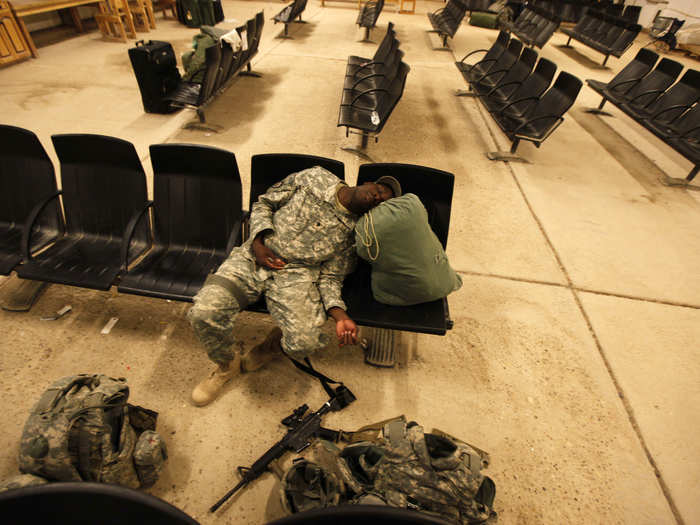 A member of the U.S. Army rests in a hall, before flying to the U.S., at al-Asad air base in Iraq