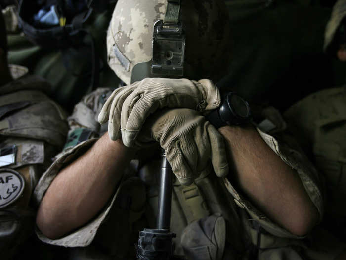 A Canadian soldier from the NATO-led coalition rests on the muzzle of his rifle as he sleeps while riding in an armoured vehicle in Kandahar province November 16, 2007.