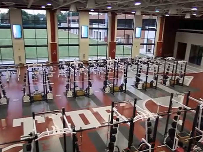 The weight room features floor-to-ceiling windows