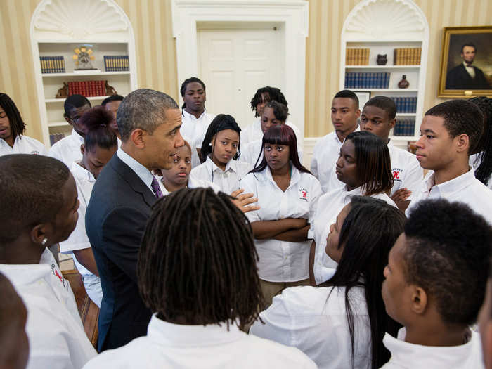 Obama talks with students from William R. Harper High School in Chicago, Ill., in the Oval Office.