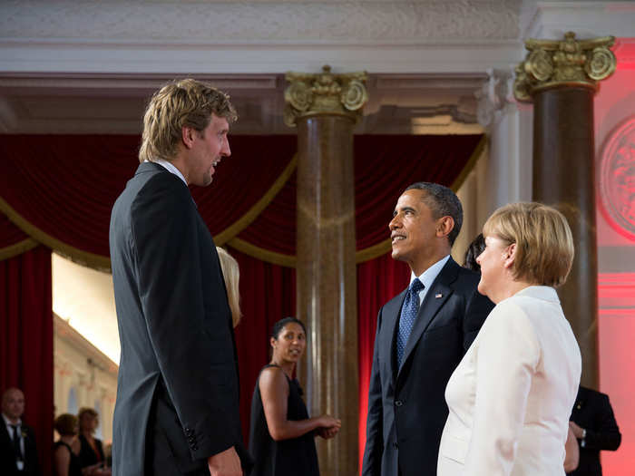 Obama and German Chancellor Angela Merkel talk with Dallas Mavericks basketball player Dirk Nowitzki before a dinner at Schloss Charlottenburg in Berlin.