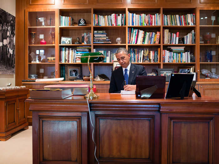 Obama signs a copy of former South African President Nelson Mandela