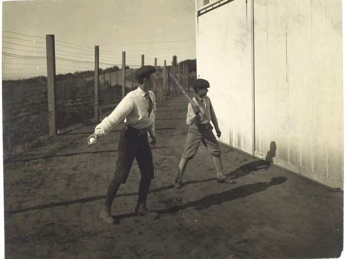 Two kids playing barn ball (1800s)