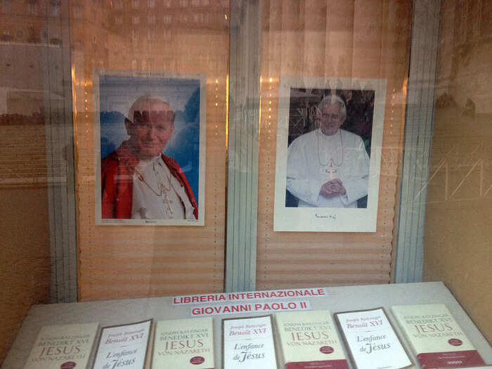 In a window in the court yard, a photo of the current Pope and the last one.