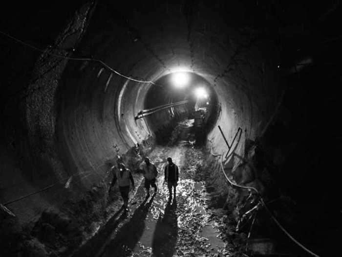 Three men cast shadows and provide a frame of reference that shows just how enormous the tunnels are.