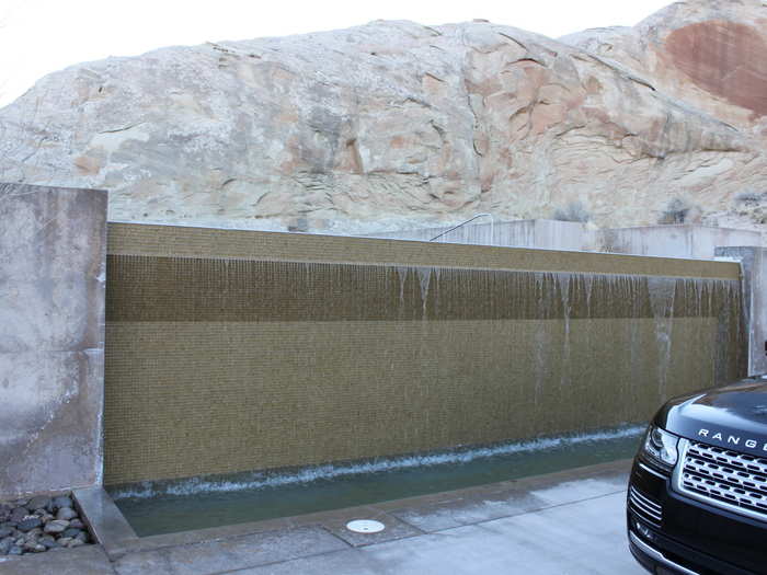 And the edge of the pool features a small waterfall. Parked there, of course, is a new Range Rover.