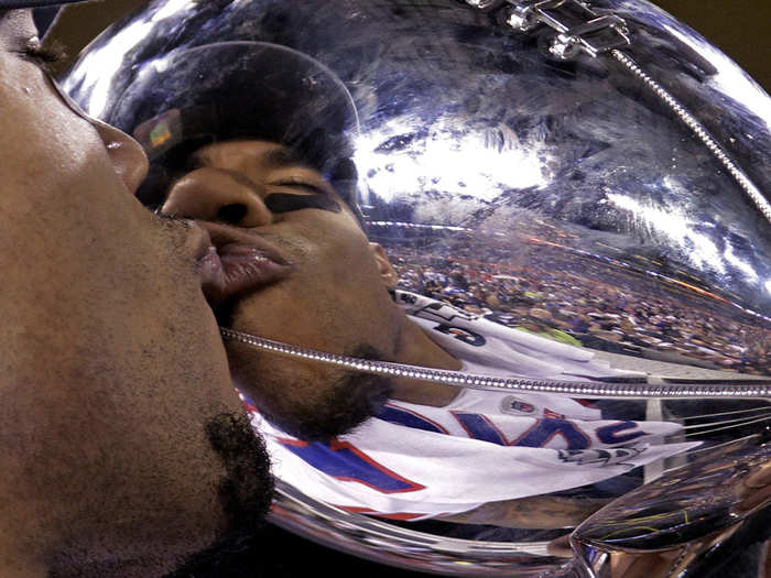 Giants wide receiver Devin Thomas kisses the trophy