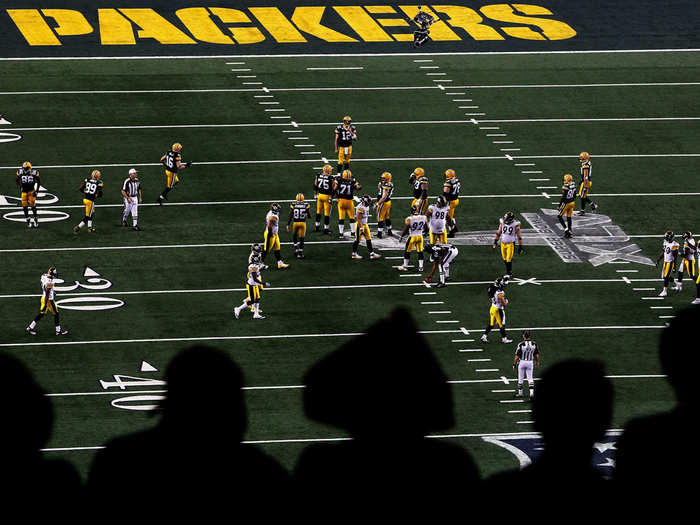 Silhouetted fans watch Super Bowl XLV