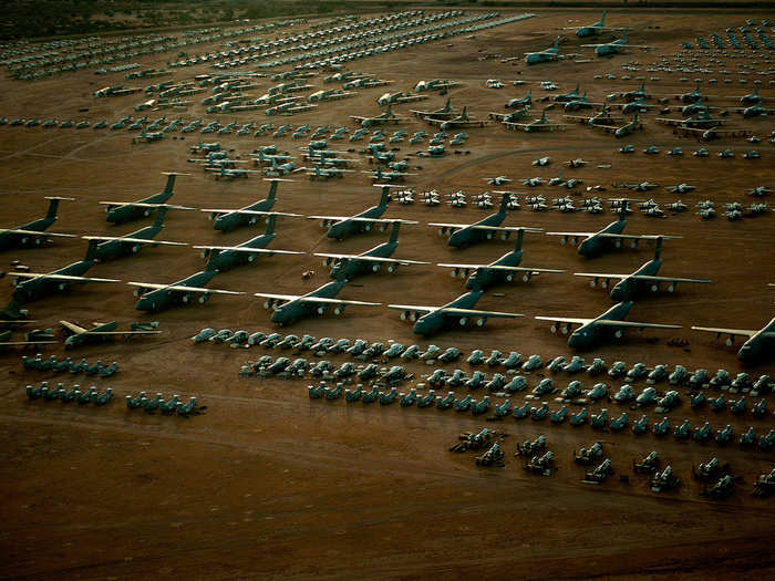 A fleet of C-5 Galaxies tower above the rest of the fighter and cargo aircraft inside the "Boneyard."