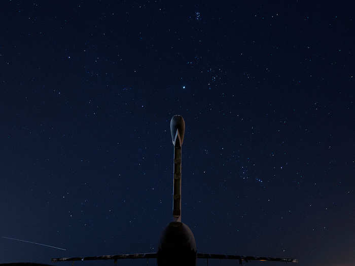 The remains of a C-5 Galaxy rise six stories into the night sky.