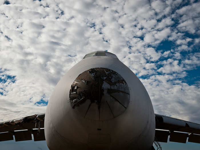 High above the ground, a C-5 Galaxy aircraft sits motionless as clouds pass by. The Galaxy used to be the Air Forces a premier military transport aircraft.