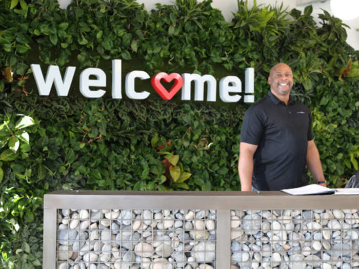 The reception area features a "living wall" of plants, and receptionist Andrew Wright.