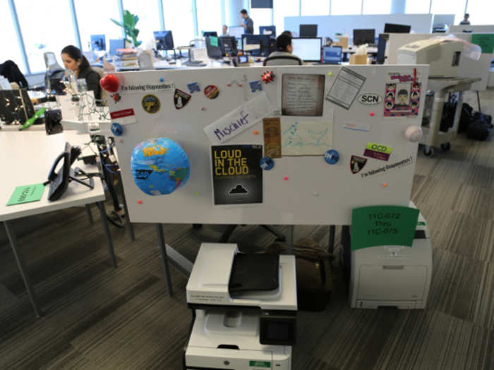 Employees work in open desk areas.