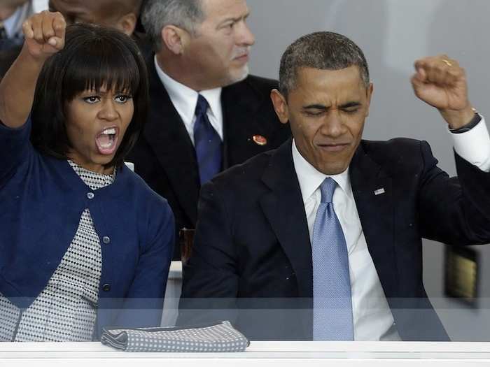 The Obamas cheer on the parade with enthusiastic fist pumps.