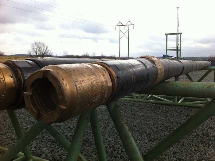 This "mud motor" pipe is what allows drillers to "make the turn" from vertical to horizontal. Workers above send fluid down the pipe, which imparts torque and allows it to turn.