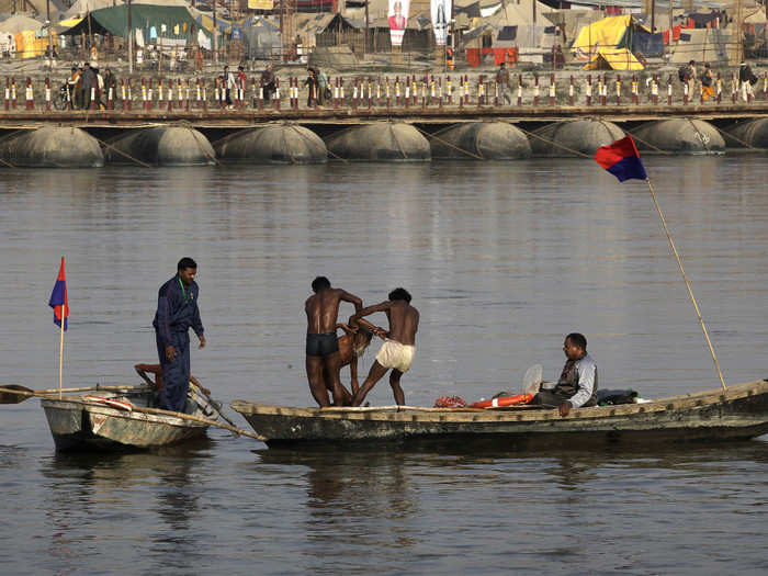 Water police rescue one of the sadhus (holy men) stuck in the mid flow at Sangam, the confluence of the rivers Ganges, Yamuna, and mythical Saraswati.