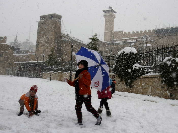 Palestinian children enjoy the snow in Hebron