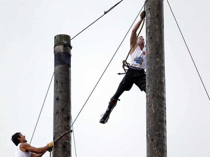 Stirling Hart of British Columbia (right) climbs 90 feet up a pole to win the open climb event.