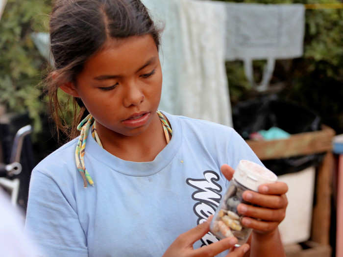 Maelia attends school as well, but spends a lot of time making necklaces from shells that she sells to tourists.