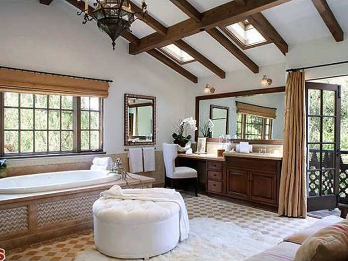 The sky-lit master bath has a vanity area, access to the porch, as well as a bathtub right near the window.