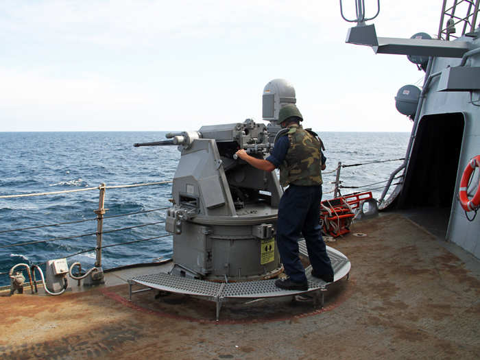 Then one of the weapons crew grabs a helmet and a flak jacket before firing manually down on deck — the cannon would be used against small craft attempting to reach the Barry under combat conditions off Syria.