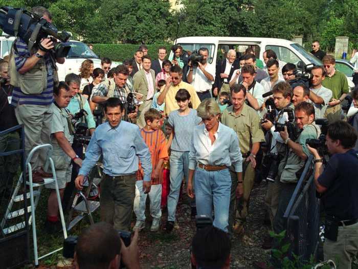 Swarms of paparazzi descend on Princess Diana and a land mind victim in front of his home in Bosnia.